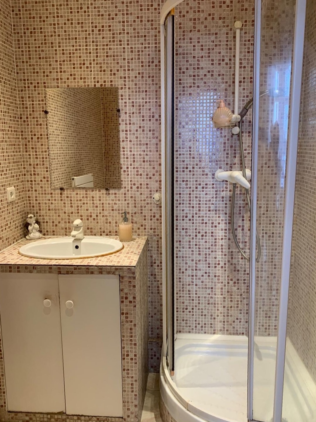 La salle de bains de l'institut, avec sa douche et son lavabo en mosaïque